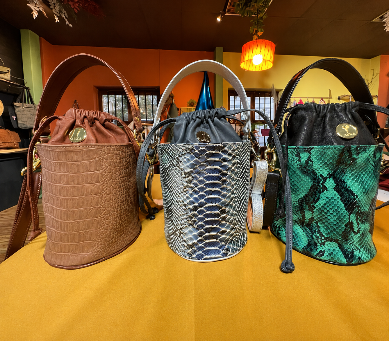 Auka bucket bags in croco and python leather